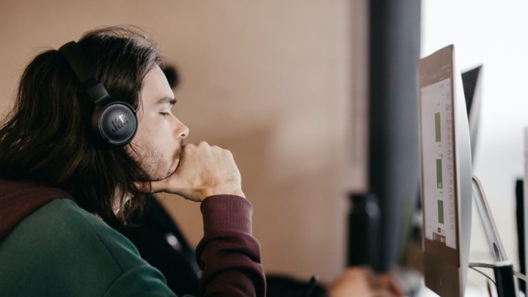 Homem com fone Bluetooth trabalhando