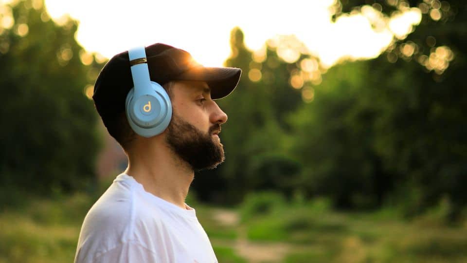 homem usando headphone bluetooth caminhando ao ar livre