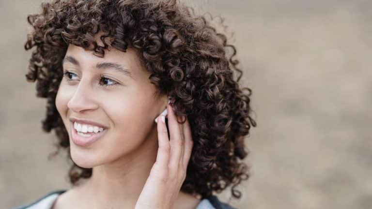 Mulher conversando com seus fones de ouvido Bluetooth