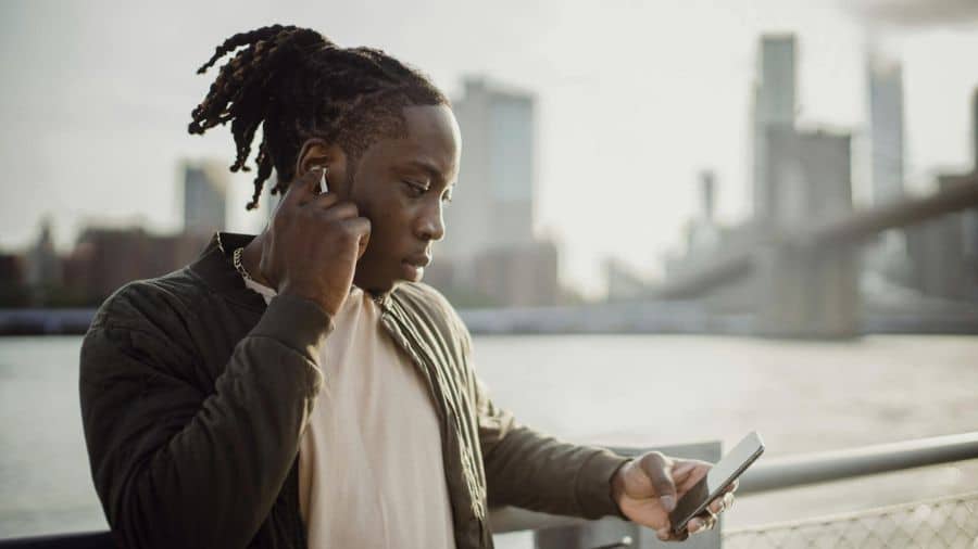 homem em conversa de audio pelo celular usando microfones do fone de ouvido bluetooth